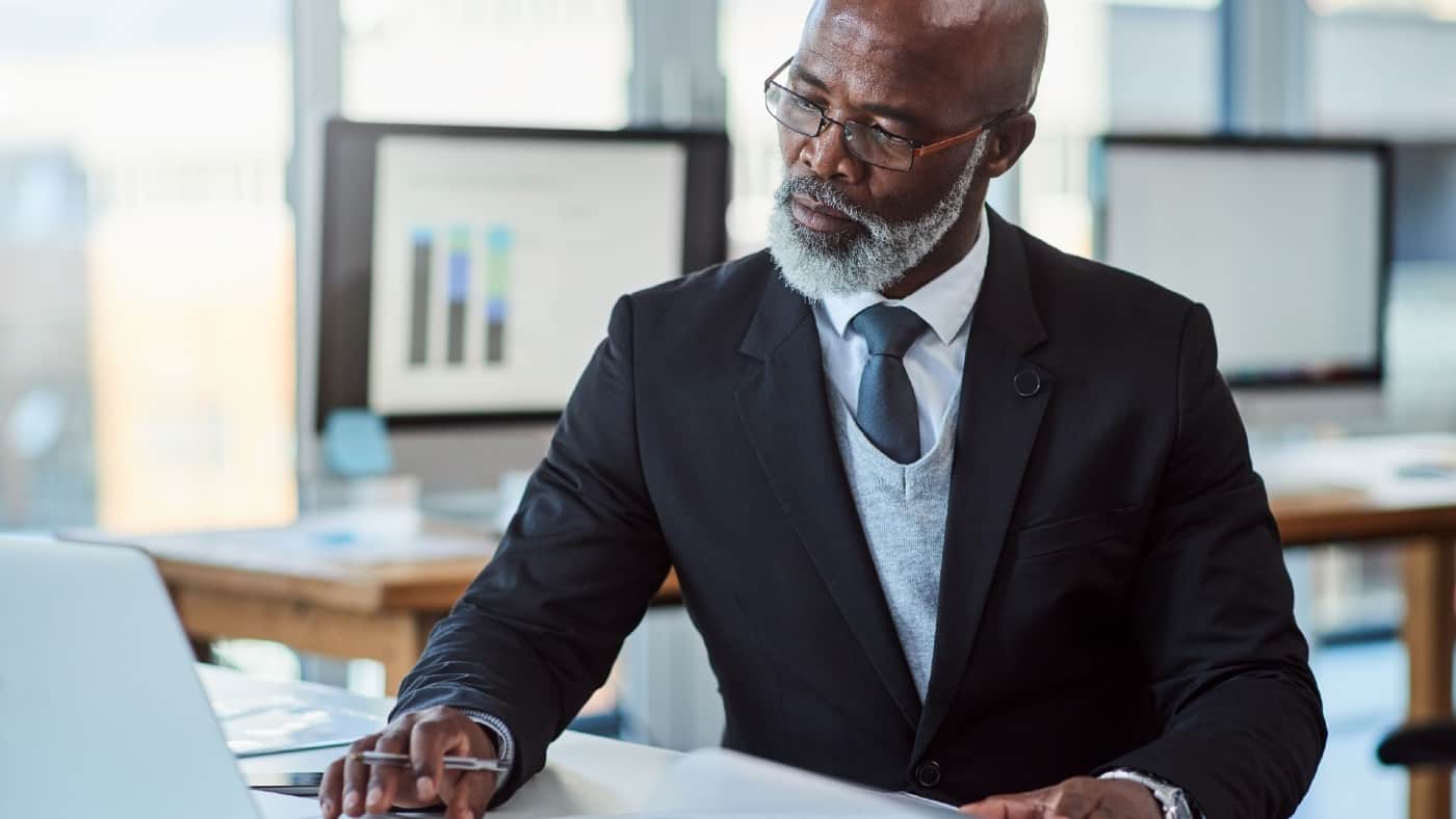 Elegantly dressed middle-aged black gentleman working at his desk